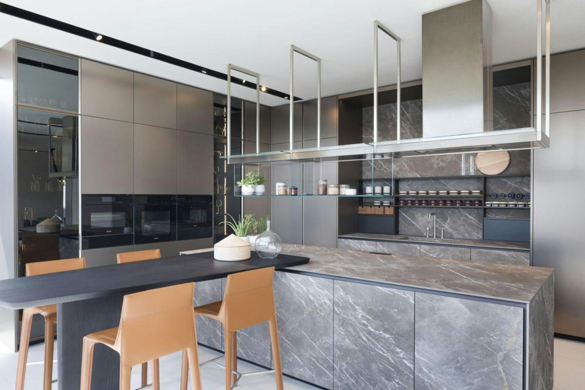 Cocina moderna con isla de mármol, gabinetes grises y barras de madera